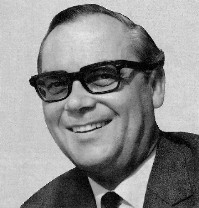 Portraitfoto in schwarz-weiß des lächelnden Bundestagesabgeordneten Leo Wagner mit dunkler Brille, Anzug und Krawatte